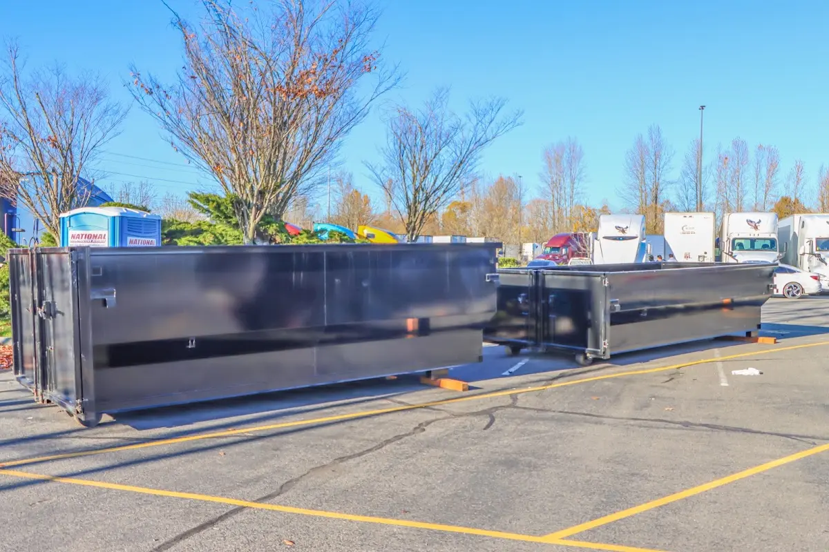 Professional dumpster rental service with roll-off container on residential driveway in Topsham